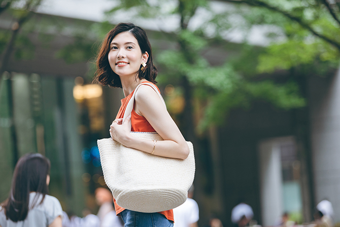 カバンを肩に掛けた笑顔の女性