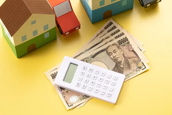 家の模型と電卓とお金