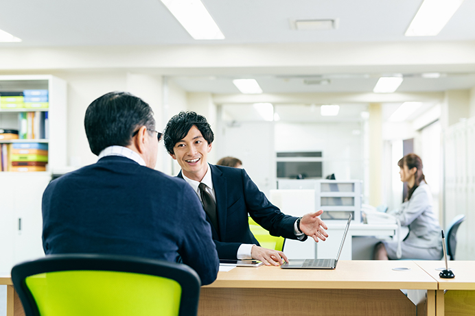 窓口で相談する男性と担当の男性