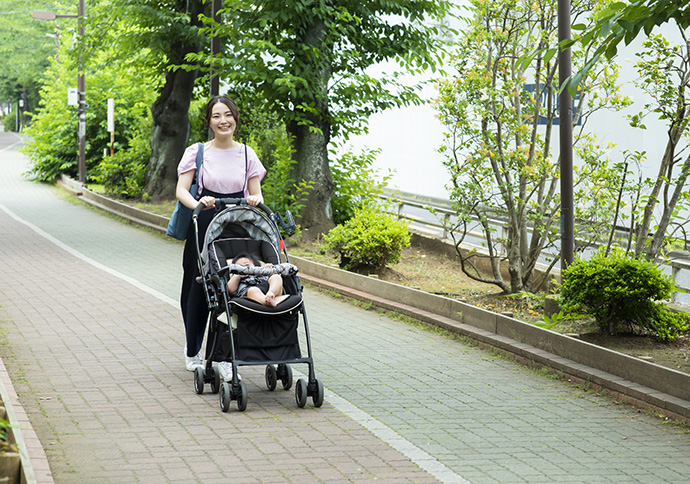 ベビーカーを引いて歩く女性