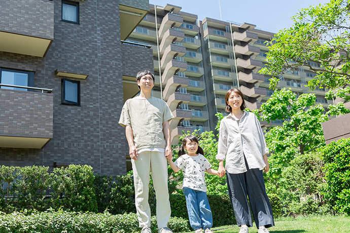マンションの前にたたずむ家族