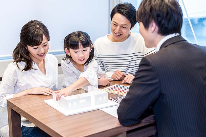 家の模型をみる家族