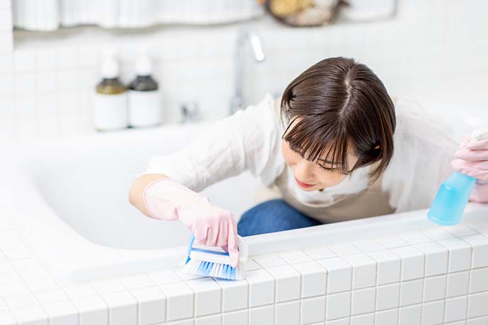 浴室内の掃除をする女性