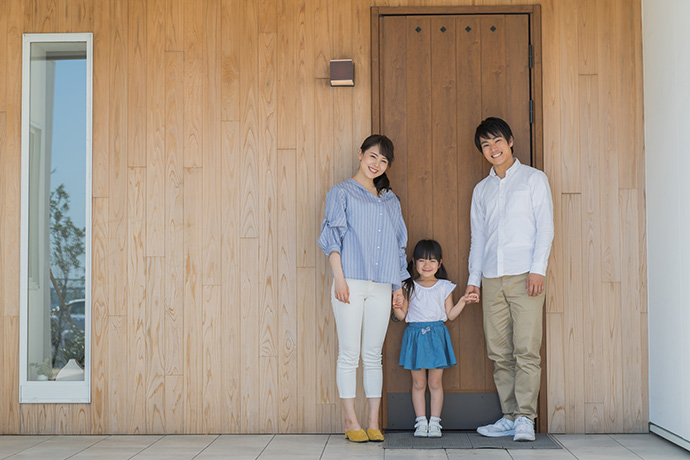 住宅の玄関前の家族