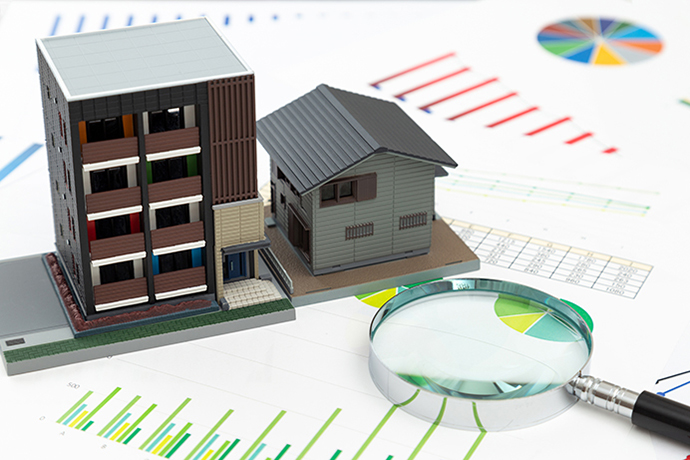 住宅模型とグラフと虫眼鏡