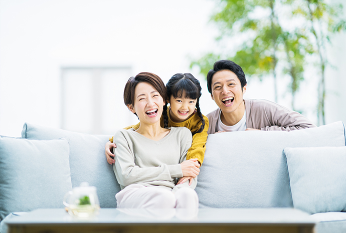 リビングンで笑う若い家族