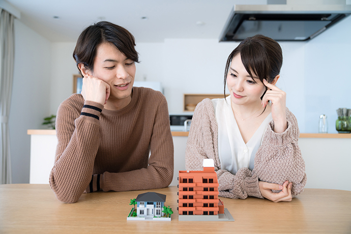 考える男女と家の模型