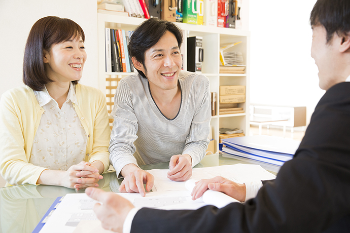 相談する夫婦とスタッフと本棚