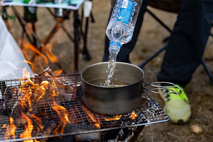 たき火でペットボトルの水を沸かす様子