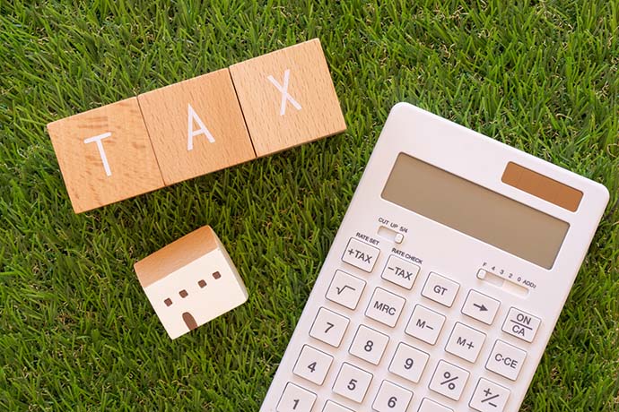 税金|「TAX」と書かれた積み木と電卓と小銭